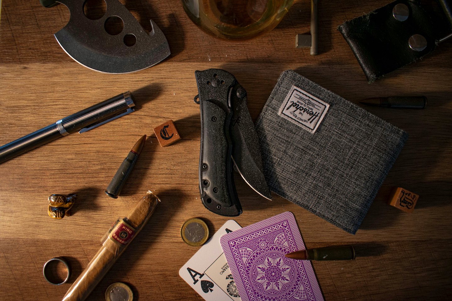 Tactical tools and personal accessories arranged on a wooden surface.